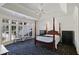Spacious main bedroom with a four-poster bed, sitting area and large windows at 510 Covington Cv, Alpharetta, GA 30022