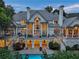Stunning rear view of the home with a pool and deck, featuring beautiful architectural details and a spacious outdoor living area at 510 Covington Cv, Alpharetta, GA 30022