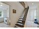 Elegant staircase with dark wood steps and wrought iron railing, adjacent to a laundry room and exterior doors at 510 Covington Cv, Alpharetta, GA 30022