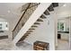 Grand staircase with dark wood treads, wrought iron railing, and light stone floors, offering a modern touch at 510 Covington Cv, Alpharetta, GA 30022