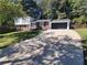 Split level home featuring a long driveway and attached garage on a sunny day at 208 Willows Ct, Riverdale, GA 30274