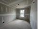 Unfinished bedroom with drywall, and a window overlooking the neighborhood at 2109 Stillhaven Pl, Douglasville, GA 30135