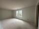 Living room with white walls, concrete floors, and a view of trees through the white-framed windows at 35 Emerald Ln, Covington, GA 30014