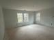 Bright, unfinished living room featuring multiple windows offering natural light and a view of the surrounding trees at 35 Emerald Ln, Covington, GA 30014