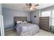 Comfortable bedroom with gray walls, soft carpet, ceiling fan, and a large upholstered bed at 3770 Summit Gate Dr, Suwanee, GA 30024