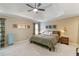 Cozy bedroom with a tray ceiling, ceiling fan, neutral walls and stylish decor at 3770 Summit Gate Dr, Suwanee, GA 30024