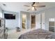 Bedroom with light gray walls, carpet, ceiling fan, a large bed and connecting bathroom at 3770 Summit Gate Dr, Suwanee, GA 30024