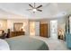 Large bedroom featuring a tray ceiling, neutral walls, carpet, stylish decor and connecting bathroom at 3770 Summit Gate Dr, Suwanee, GA 30024