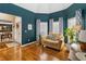 Inviting sitting room with large windows, hardwood floors, and blue accent wall, perfect for relaxation at 3770 Summit Gate Dr, Suwanee, GA 30024