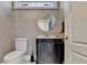 Elegant bathroom featuring a decorative vanity with a black cabinet, white sink, and a round mirror at 3871 River Mansion Dr, Peachtree Corners, GA 30096