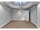 Spacious bedroom with neutral walls, plush carpeting, and decorative tray ceiling with crown molding detail at 3871 River Mansion Dr, Peachtree Corners, GA 30096