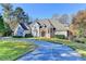 Beautiful two-story home with a circular driveway and well-manicured lawn at 3871 River Mansion Dr, Peachtree Corners, GA 30096