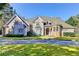 Charming two-story home with a circular driveway and manicured lawn at 3871 River Mansion Dr, Peachtree Corners, GA 30096