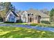 Beautiful two-story home with a circular driveway and well-manicured lawn at 3871 River Mansion Dr, Peachtree Corners, GA 30096