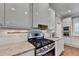 Modern kitchen with stainless steel stove, granite countertop, and sleek white cabinets at 3871 River Mansion Dr, Peachtree Corners, GA 30096