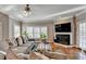 Living room with hardwood floors, fireplace, bright windows, and ceiling fan at 3871 River Mansion Dr, Peachtree Corners, GA 30096