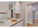 Stylish wet bar with granite countertops, mirrored backsplash, and white cabinetry, offering a luxurious entertaining space at 3871 River Mansion Dr, Peachtree Corners, GA 30096