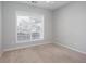 Neutral bedroom with a light beige carpet and a window with white blinds overlooking houses at 500 Sapphire Valley Ln, Canton, GA 30114