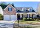 Charming two-story home with a brick facade, covered porch, and well-maintained landscaping at 500 Sapphire Valley Ln, Canton, GA 30114