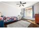 Sunlit bedroom with hardwood floors, a comfortable bed with colorful quilt, and a desk area near the window at 152 Park Dr, Decatur, GA 30030