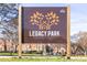 Sign for Legacy Park, a City of Decatur park, with trees and a brick building in the background at 152 Park Dr, Decatur, GA 30030