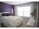 Bright bedroom with large window, purple accent wall, and white furnishings at 200 Stone Lake Dr, Dallas, GA 30157