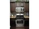 A kitchen featuring granite countertops, stainless steel appliances, and dark wood cabinets at 200 Stone Lake Dr, Dallas, GA 30157