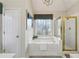 Bright bathroom featuring a tub, shower and decoratively framed window at 4212 Lazy Creek Dr, Marietta, GA 30066