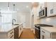 Modern kitchen features white cabinets, stainless appliances, a sleek black faucet, and wood floors at 163 Bluffington Way, Marietta, GA 30066