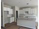 Bright, unfinished kitchen features white cabinets, granite countertops and a central island at 188 Balsam Dr, Dallas, GA 30157