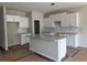 Bright, unfinished kitchen features white cabinets, granite countertops and a central island at 188 Balsam Dr, Dallas, GA 30157