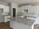 Bright, unfinished kitchen features white cabinets, granite countertops and a central island at 188 Balsam Dr, Dallas, GA 30157