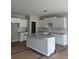 Bright, unfinished kitchen features white cabinets, granite countertops and a central island at 188 Balsam Dr, Dallas, GA 30157