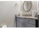 Powder room features granite countertop vanity with gray cabinetry and a decorative oval mirror at 381 Gainesborough Dr, Dallas, GA 30157