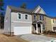 New two-story home with gray siding, brick accents, and a two-car garage at 4300 Easter Lily Ave Lot 11, Buford, GA 30519