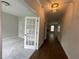 Interior view of a hallway featuring hardwood floors, neutral walls, and a decorative light fixture at 4300 Easter Lily Ave Lot 11, Buford, GA 30519
