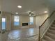 Spacious living room featuring a fireplace, staircase, and access to the backyard at 4300 Easter Lily Ave Lot 11, Buford, GA 30519