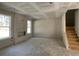 Unfinished living room with staircase, modern fireplace, and natural light at 4300 Easter Lily Ave Lot 11, Buford, GA 30519