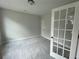 Neutral room with gray carpet, gray walls, and natural light coming through a set of french doors at 4300 Easter Lily Ave Lot 11, Buford, GA 30519