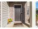 Close-up of a welcoming front door with brick and siding accents and a decorative welcome mat at 891 Feldman Chase, Loganville, GA 30052
