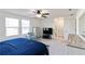 Bright main bedroom with a ceiling fan, two large windows and a light blue chair at 891 Feldman Chase, Loganville, GA 30052