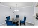 Dining room with modern chandelier and glass table, complemented by blue chairs at 2006 Riverview Dr, Marietta, GA 30067