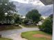 Suburban street view featuring well-maintained homes with mature trees and landscaped yards under a cloudy sky at 3348 Summit Turf Ln, Snellville, GA 30078
