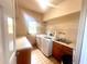 Bright laundry room featuring modern washer and dryer, storage shelves, wash sink, and natural lighting at 3348 Summit Turf Ln, Snellville, GA 30078
