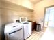 Bright laundry room with tile floors features modern washer and dryer, storage shelves, and convenient wash sink at 3348 Summit Turf Ln, Snellville, GA 30078
