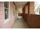 Long, covered brick porch and pink exterior walls with windows and outdoor lighting at 3348 Summit Turf Ln, Snellville, GA 30078