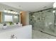 Modern bathroom featuring double sinks, a large mirror, a glass shower, and marble floors at 216 Tennis Court Nw Ln, Kennesaw, GA 30144