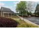 Community clubhouse with well-manicured landscaping and a glimpse of the tennis court at 216 Tennis Court Nw Ln, Kennesaw, GA 30144
