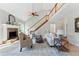 Inviting living room with a stone fireplace, staircase, and vaulted ceilings at 216 Tennis Court Nw Ln, Kennesaw, GA 30144