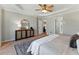 Bedroom boasts tray ceiling, neutral walls, a ceiling fan, and a view of other rooms in the home at 216 Tennis Court Nw Ln, Kennesaw, GA 30144